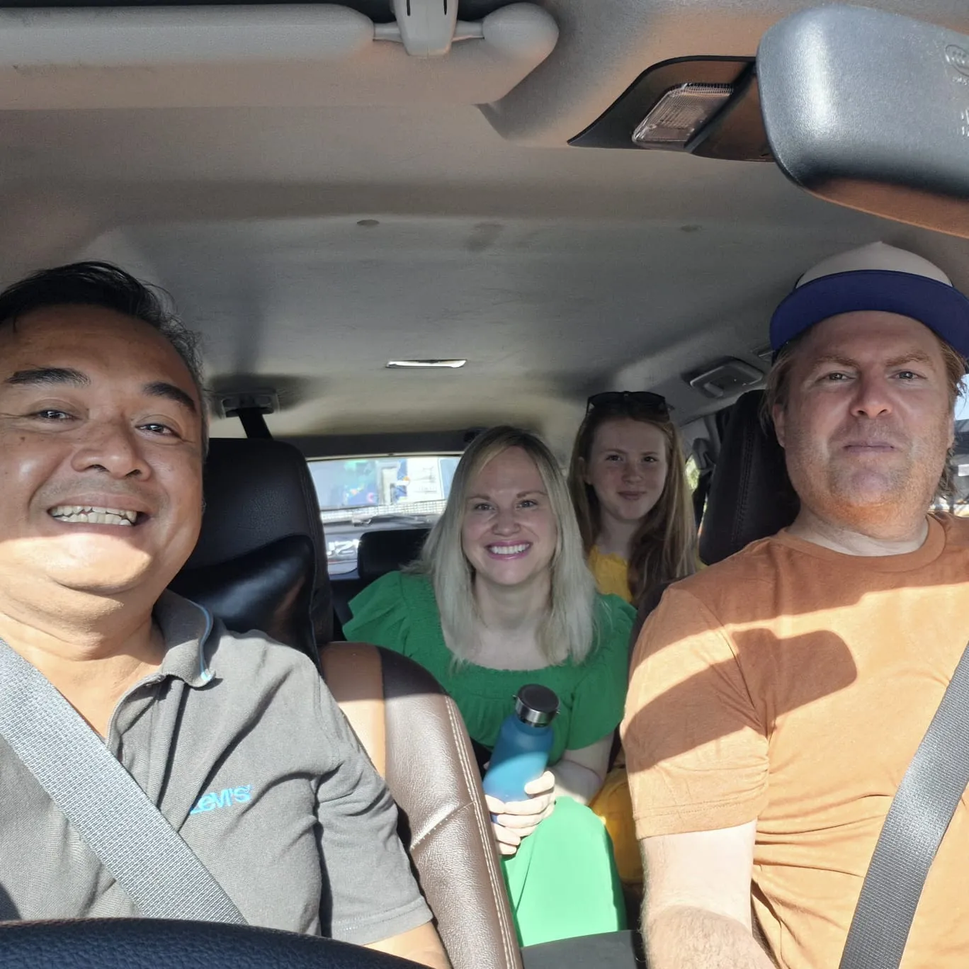 Wayan Wid welcoming a family inside a private Bali tour vehicle