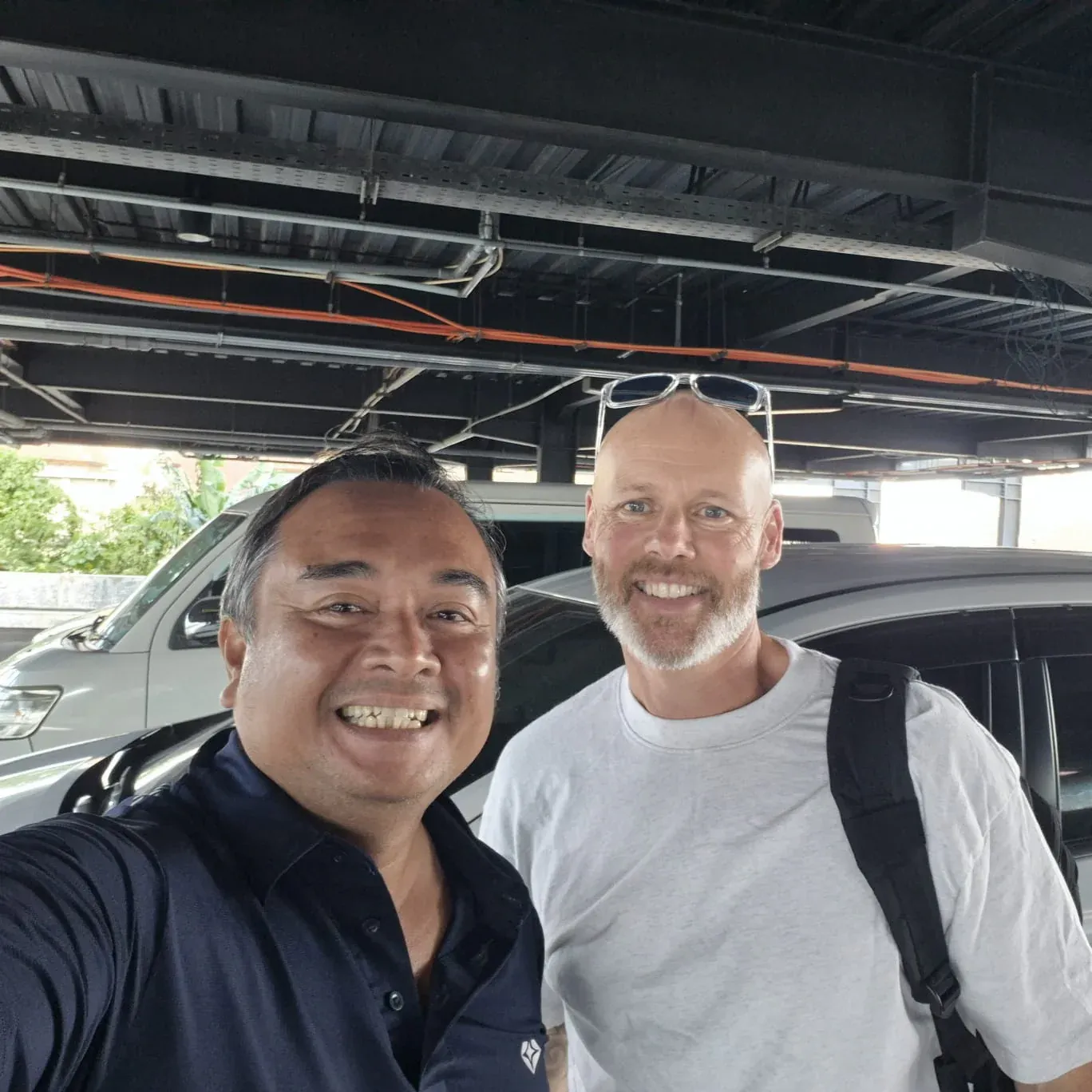 Wara Bali Tour driver and guest smiling beside their vehicle