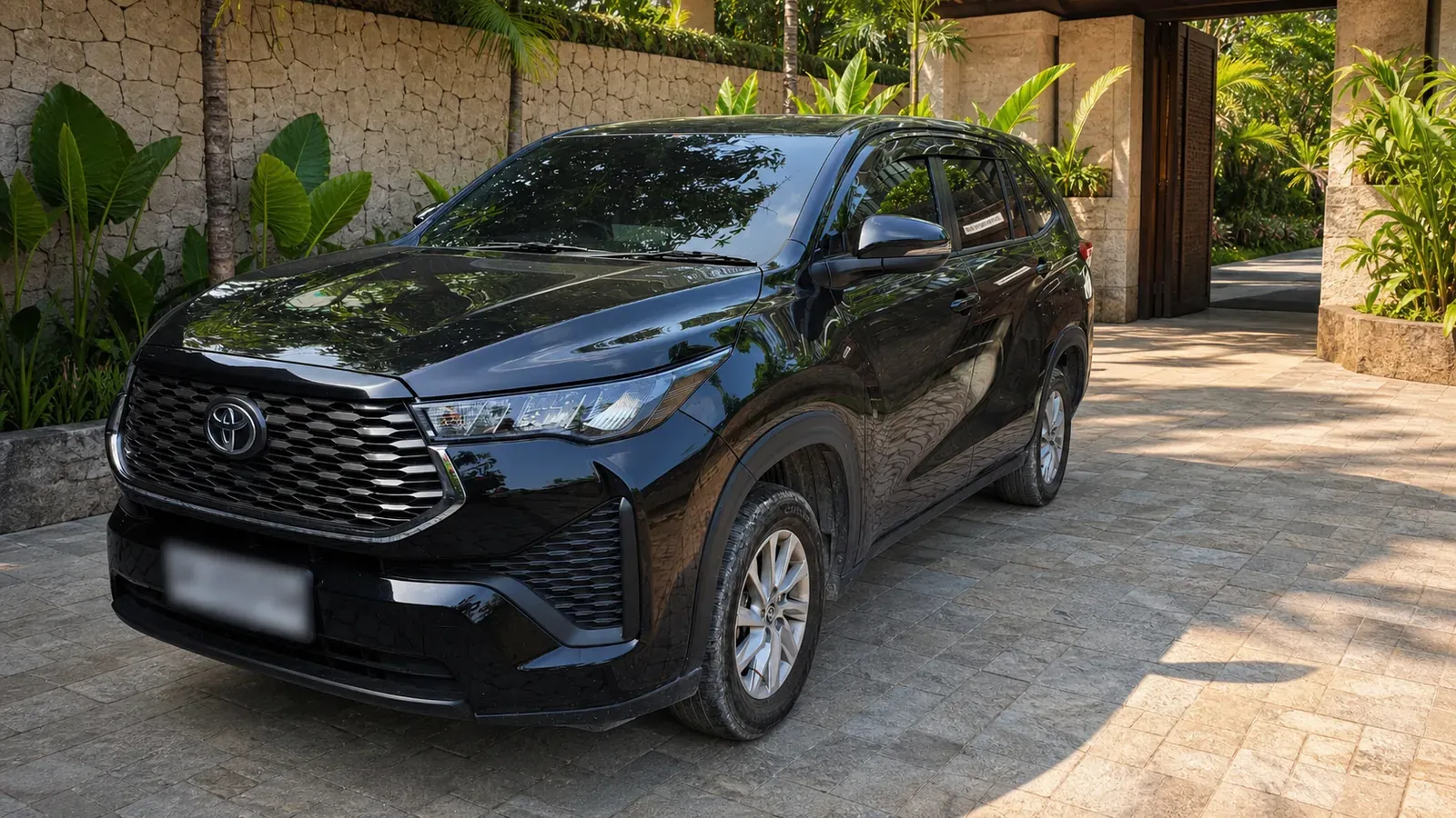 Black Toyota Innova Zenix at a Balinese resort driveway